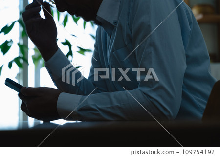 一名中年男子看到自己的智慧型手機時感到震驚 一名中年男子看到自己的智慧型手機時感到震驚 109754192