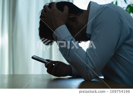 一名中年男子看到自己的智慧型手機時感到震驚 一名中年男子看到自己的智慧型手機時感到震驚 109754198