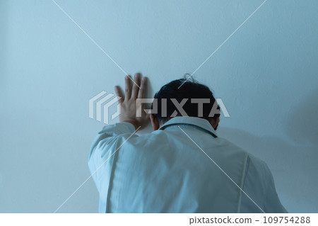 A man in work clothes touching the wall 109754288