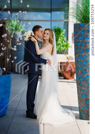Happy bride and groom on the terrace of a multi-storey hotel. 109755254