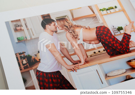 The pages of a photo book with color photos of a pregnant blonde and a man.  109755346