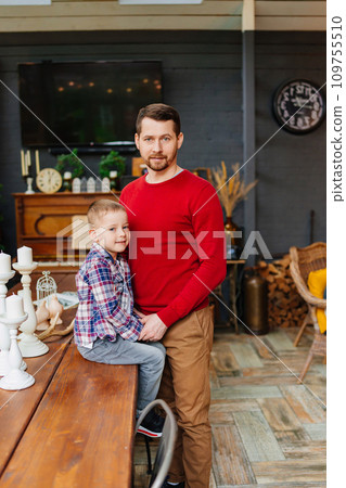 Dad with little son on wooden table in retro style country house room. Dad with little son on wooden table in retro style country house room. 109755510