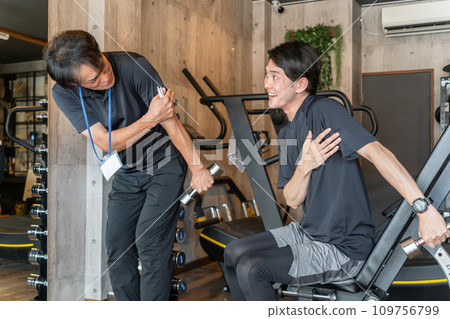 Young Asian man receiving rehabilitation and personal training from a sports trainer at a sports gym 109756799
