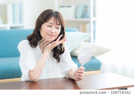 Middle-aged woman doing skin care in the living room 109758582