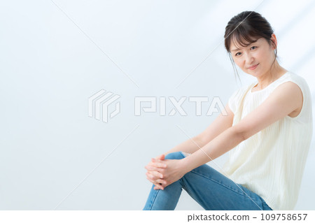A middle-aged woman doing skin care against a white background A middle-aged woman doing skin care against a white background 109758657