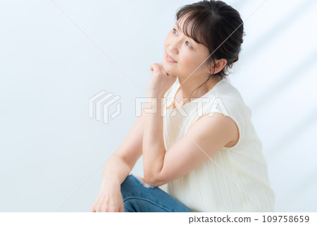 一位中年婦女在白色背景下做皮膚護理 109758659