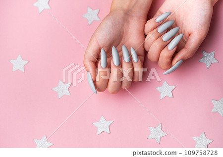 Hands with grey manicure on a pink background Hands with grey manicure on a pink background 109758728