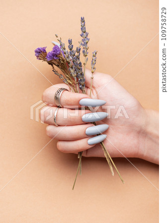 Close-up of a woman's hands with grey manicured nails Close-up of a woman's hands with grey manicured nails 109758729