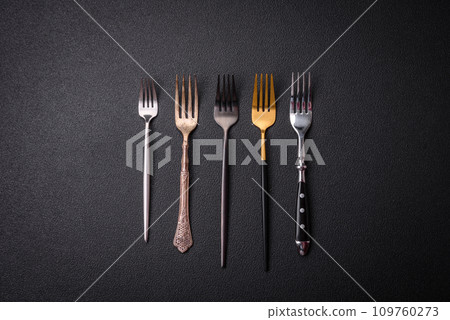 Kitchen fork made of steel on a dark textured background Kitchen fork made of steel on a dark textured background 109760273
