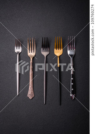 Kitchen fork made of steel on a dark textured background Kitchen fork made of steel on a dark textured background 109760274