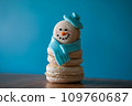 Snowman macaron dessert decorated with hat and scarf against blue background. Merry Christmas and Happy New Year festive concept 109760687