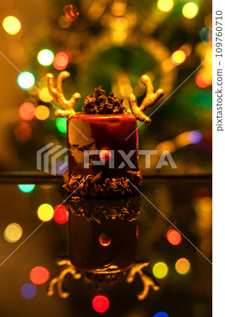 Chocolate reindeer cake with brown cream frosting decorated with antlers against colorful lights and bokeh background. Merry Christmas and Happy New Year festive concept Chocolate reindeer cake with brown cream frosting decorated with antlers against colorful lights and bokeh background. Merry Christmas and Happy New Year festive concept 109760710