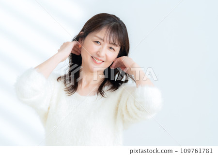 一位中年婦女在白色背景下做皮膚護理 109761781