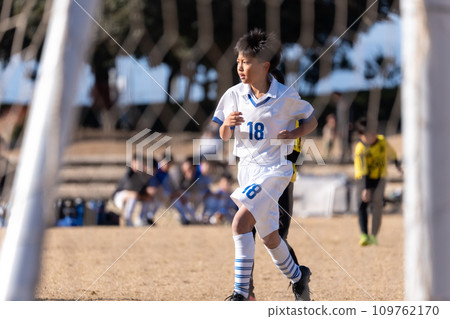 Elementary school boy playing soccer match 109762170