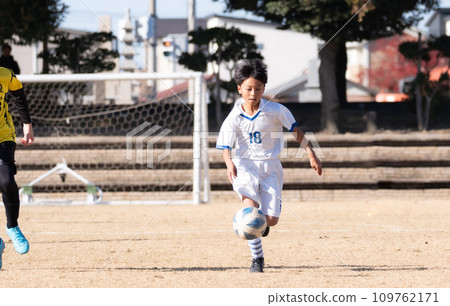 Elementary school boy playing soccer match 109762171