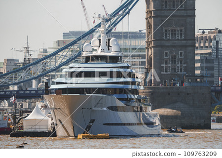 Luxurious cruise ship moored on Thames river. Iconic Tower bridge and buildings with sky in background. Famous tourist attraction in capital city of London. 109763209