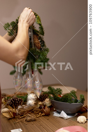 Woman making Christmas arrangement with fir branches. craft handmade decor. 109763900
