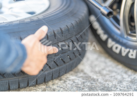 Tire exchange, studless tires, removing pebbles from the grooves Tire exchange, studless tires, removing pebbles from the grooves 109764291