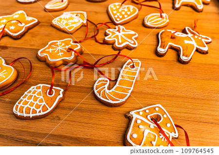 Wooden background with lots of gingerbread Christmas gingerbread in the shape of a house, heart. Deer. star, christmas tree toy, ball with white glaze. High quality photo Wooden background with lots of gingerbread Christmas gingerbread in the shape of a house, heart. Deer. star, christmas tree toy, ball with white glaze. High quality photo 109764545