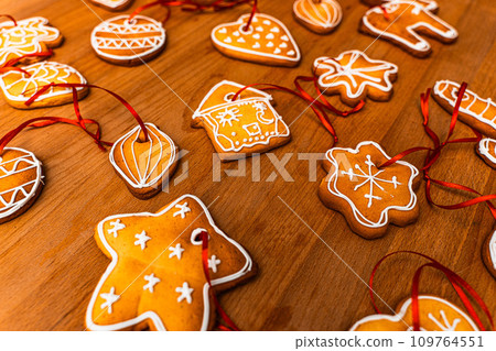 Wooden background with lots of gingerbread Christmas gingerbread in the shape of a house, heart. Deer. star, christmas tree toy, ball with white glaze. High quality photo Wooden background with lots of gingerbread Christmas gingerbread in the shape of a house, heart. Deer. star, christmas tree toy, ball with white glaze. High quality photo 109764551