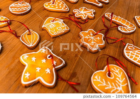 Wooden background with lots of gingerbread Christmas gingerbread in the shape of a house, heart. Deer. star, christmas tree toy, ball with white glaze. High quality photo Wooden background with lots of gingerbread Christmas gingerbread in the shape of a house, heart. Deer. star, christmas tree toy, ball with white glaze. High quality photo 109764564