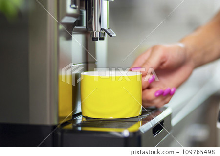 A woman makes fresh flavored coffee with a modern coffee machine in her kitchen 109765498