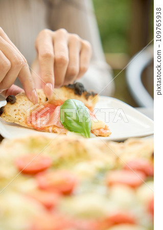 Woman eating pizza at a cafe Woman eating pizza at a cafe 109765938
