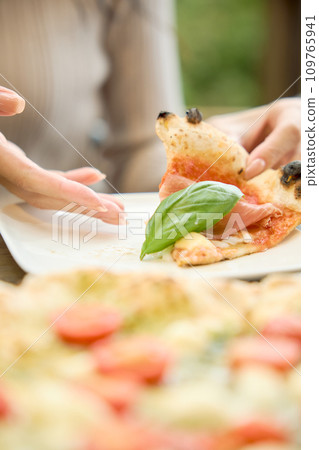 Woman eating pizza at a cafe Woman eating pizza at a cafe 109765941