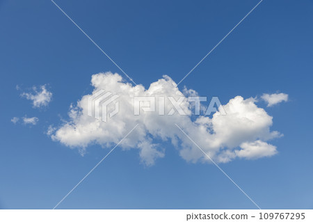 Large cumulus cloud brilliantly lit against a blue sky, creating a striking picturesque sky scene Large cumulus cloud brilliantly lit against a blue sky, creating a striking picturesque sky scene 109767295