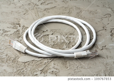 White network cable patch-cord on gray textured background 109767853