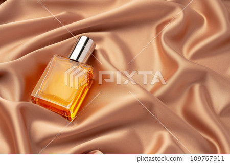 Glass bottle with serum or cosmetic oil on silk fabric background Glass bottle with serum or cosmetic oil on silk fabric background 109767911