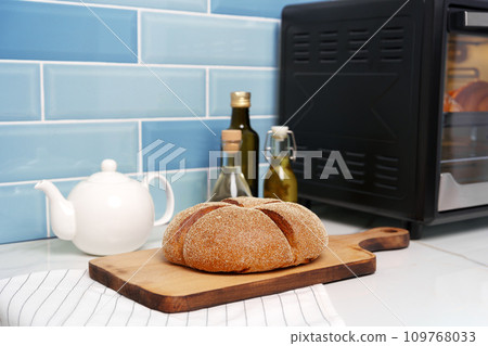 Fresh bread on wooden cutting board in the kitchen 109768033