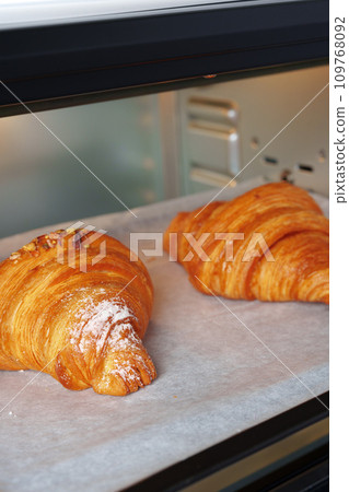 Modern mini electric oven with freshly baked croissants in kitchen 109768092