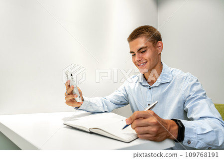 Young handsome entrepreneur using his mobile phone in the office Young handsome entrepreneur using his mobile phone in the office 109768191