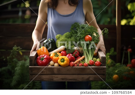 Young girl holds a box with vegetables 109768584