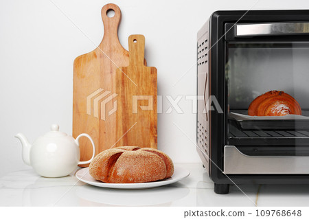 Modern mini electric oven with freshly baked croissants in kitchen 109768648