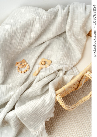 Muslin blanket and wooden toys in baby cradle Muslin blanket and wooden toys in baby cradle 109768854