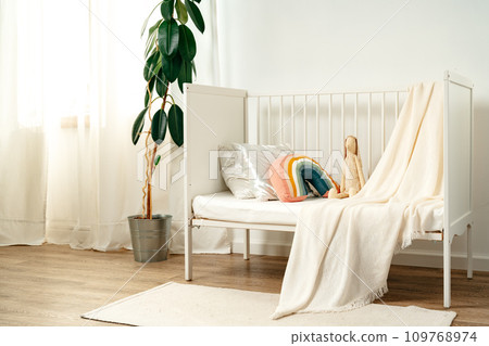 White wooden baby crib in nursery room 109768974
