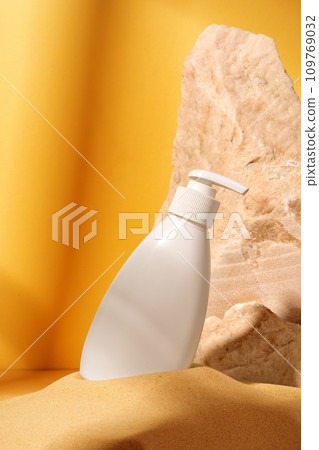 Bottle of sunscreen lotion against orange background 109769032