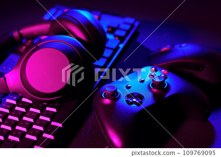 Headphones, joystick and computer keyboard on black table Headphones, joystick and computer keyboard on black table 109769095