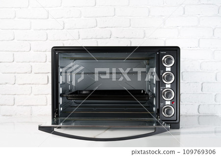 Mini electric oven against white brick wall in the kitchen 109769306