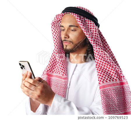 Young Arab man in traditional dress thobe using smartphone at white background 109769523