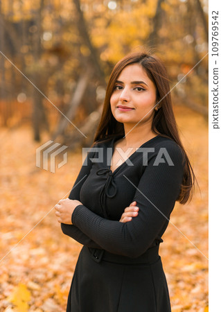 Close up portrait of pretty indian young woman enjoying warm autumn sunny day vacation outdoors. Generation z and gen z concept. Fall Season Close up portrait of pretty indian young woman enjoying warm autumn sunny day vacation outdoors. Generation z and gen z concept. Fall Season 109769542