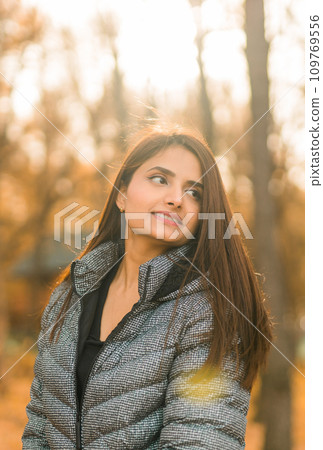 Close up portrait of pretty indian young woman enjoying warm autumn sunny day vacation outdoors copy space mockup. Generation z and gen z concept. Fall Season Close up portrait of pretty indian young woman enjoying warm autumn sunny day vacation outdoors copy space mockup. Generation z and gen z concept. Fall Season 109769556