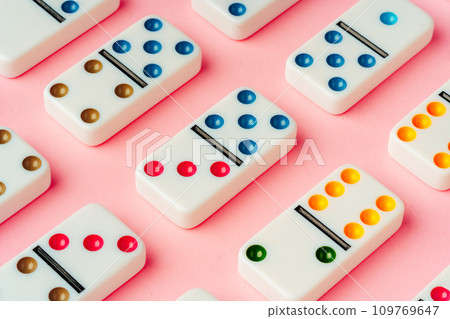 A pattern of domino pieces on pink background A pattern of domino pieces on pink background 109769647