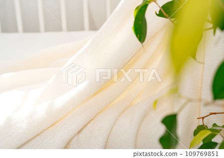 Soft cotton blanket hanging on baby's bed Soft cotton blanket hanging on baby's bed 109769851