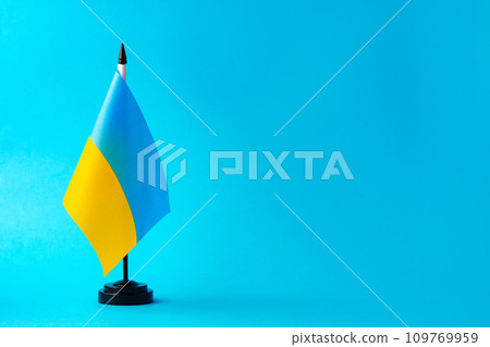 Small flag of Ukraine on blue background Small flag of Ukraine on blue background 109769959
