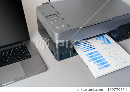 Printer and laptop on grey table in office Printer and laptop on grey table in office 109770254