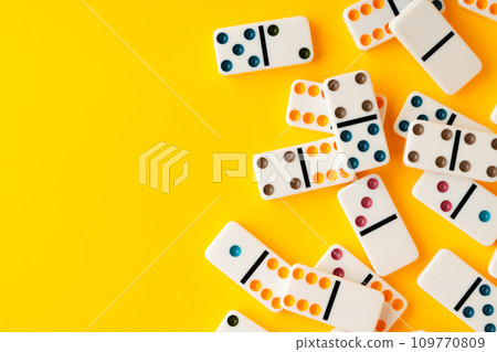 Domino tiles on yellow background studio shot Domino tiles on yellow background studio shot 109770809