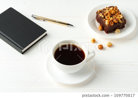 Piece of brownie cake with hazelnuts on white background 109770817